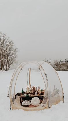 the inside of a tent in the snow with food and drinks set up on it