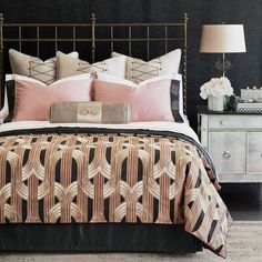 a bed with pink and black comforter in a bedroom next to a night stand