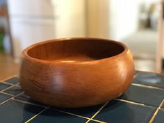 a wooden bowl sitting on top of a tiled counter