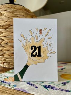 a card with the number 21 on it is sitting on a table next to a basket