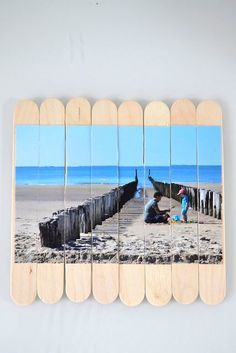 a group of wooden pictures hanging on the wall next to each other in front of a beach