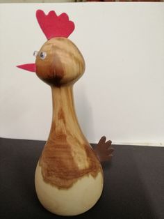 a wooden duck with a red heart on its head