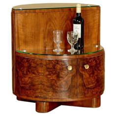 a wooden cabinet with wine glasses and a bottle on the top, next to it