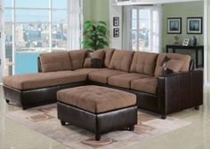 a living room with a large brown sectional couch and footstool in front of a window