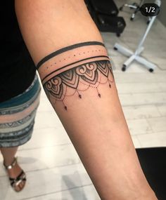 a woman's arm with a tattoo on it that has an intricate design and beads