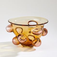 The Bubbled Bowl is made in a small art glass factory located in the southeastern point of Poland. The artisans first form the amber glass in a mold. Using a round tool, the interior bubbles in the abstract shape are pushed out of the wall of the vase creating a blush color tone. Lastly, the glass is annealed for over 24 hours to cool. Each piece is unique, so shape and color may vary. Dimensions Overall 8.5"H x 13.5"Dia. (6.6 lbs)  Hand wash  Product is Watertight Product is Food Safe Washington Street, Abstract Shape, Global Views, Find Objects, Jewellery Brand, Small Art, Color Tone, Blush Color, Amber Glass