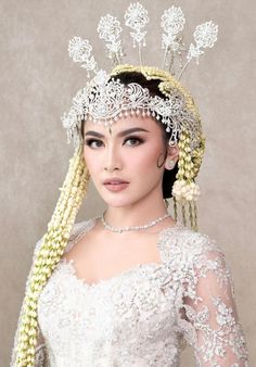 a woman wearing a white dress and headpiece