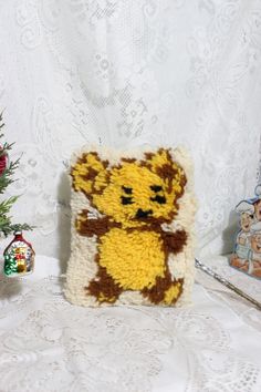 a small stuffed animal sitting on top of a white table next to a christmas tree