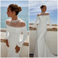 a woman in a white dress standing next to the ocean