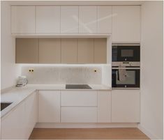 a white kitchen with an oven, sink and microwave