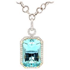 This stunning necklace features a magnificent 51.47 carat emerald-cut aquamarine with extraordinary blue color! The gem is surrounded by fine diamonds in an original pendant that is beautiful from every angle. The aquamarine is a perfectly proportioned "modified brilliant cut," with a rectangular outline and diamond-shaped facets that give this gemstone superior brilliance and life! We set this gorgeous blue gem in 18k yellow gold with double prongs and a custom designed 18k yellow gold basket. Luxury Aquamarine Solitaire Jewelry, Luxury Aquamarine Fine Jewelry Necklace, Aquamarine Emerald-cut Diamond Jewelry, Luxury Aquamarine Gemstone Necklace, Luxury Diamond-cut Blue Topaz Necklace, Diamond Enhancer, Gold Basket, Artisan Necklace, Gold Statement Necklace