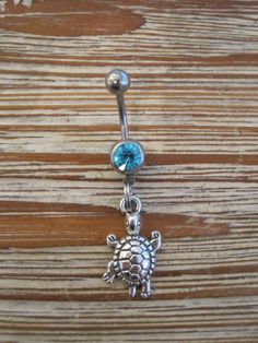 This super cute belly button ring that features a silver turtle charm that hangs from a standard 14 gauge surgical steel barbell with a light blue gem. It measures 3/4 inches long. Thanks for taking a look!   *If you would like this belly button ring in a different color gem or stone, just let me know. I would love to make it for you!* Silver Dangle Belly Rings Nickel Free, Nickel-free Silver Dangle Belly Rings, Silver Surgical Steel Belly Rings As Gift, Adjustable Nickel-free Sterling Silver Belly Ring, Adjustable Internally Threaded Silver Belly Rings, Adjustable Silver Surgical Steel Belly Rings, Silver Hypoallergenic Dangle Belly Rings, Hypoallergenic Silver Dangle Belly Rings, Silver Hypoallergenic Surgical Steel Belly Rings