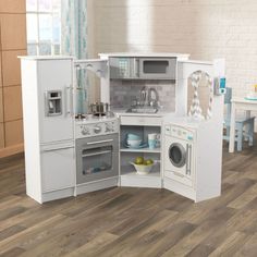 a play kitchen with white appliances and wooden floors