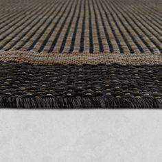 an area rug with black and tan stripes