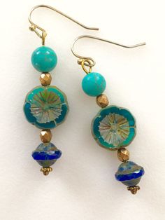 "Lightweight earrings handmade of semi-transparent aqua blue Czech glass Picasso flower, 8mm turquoise howlite, and cobalt blue Picasso UFO bead. Accented with light bronze Czech glass beads and gold wire. Earrings come on simple gold plated fish hook ear wires, lead and nickel free. Measure 2 1/8\"'long from top of ear wire." Blue Round Beaded Earrings With Spacer Beads, Blue Flower Earrings For Jewelry Making, Turquoise Czech Glass Beaded Earrings, Handmade Turquoise Beaded Earrings With Czech Glass, Turquoise Czech Glass Flower Earrings For Gift, Turquoise Glass Drop Earrings, Adjustable Flower Shaped Blue Beaded Earrings, Blue Earrings With Spacer Beads For Gift, Turquoise Glass Earrings For Gift