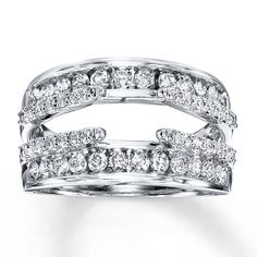 two rows of white gold and diamond rings on top of each other, with the middle one being surrounded by smaller diamonds