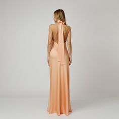 A captivating blend of elegance and allure, our Orla Open Back Halter Dress exudes undeniable charm. Tailored with a flattering bias cut from coral double silk satin, it drapes gracefully over the silhouette. The halter neckline delicately frames the shoulders, while the revealing back adds a note of sensuality. For a playful and feminine look, you can transform the silk tie neck into a chic bow, or you can let it drape loosely, adding a touch of laid-back sophistication to your ensemble.  Wear Feminine Silk Evening Dress With Fitted Bodice, Backless Satin Dress With Bias Cut For Formal Occasions, Elegant Bias-cut Floor-length Satin Dress, Elegant Modal Satin Dress With Bias Cut, Formal Silk Dress With Bias Cut, Formal Bias Cut Silk Dress, Formal Backless Satin Dress With Bias Cut, Feminine Modal Satin Wedding Dress, Elegant Bias-cut Satin Dress