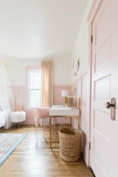 a bedroom with pink walls and wooden floors