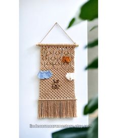 a woven wall hanging with tassels and other things on it's side