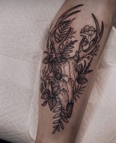 a black and white photo of a deer skull with flowers