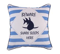 a blue and white striped pillow with a shark on it's side that says beware shark sleeps here