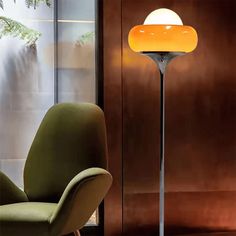 a green chair sitting next to a tall lamp