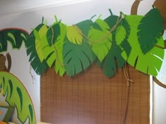 a bunch of green leaves hanging from the side of a wall next to a window