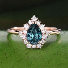 an engagement ring with a pear shaped blue diamond surrounded by small white and pink diamonds