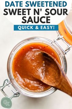 a jar filled with sauce sitting on top of a table next to a wooden spoon