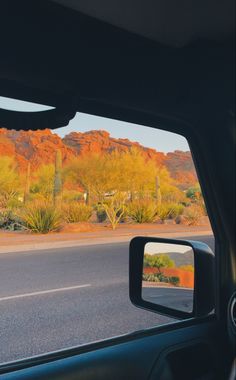 the view from inside a car looking at mountains and cactus