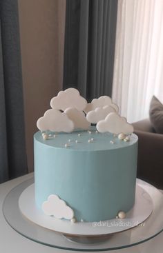 a blue cake with white clouds on top