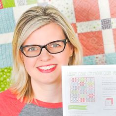 a woman in glasses holding up a piece of paper