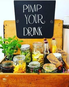 a wooden crate filled with mason jars and other items next to a chalkboard sign that says pimp your drink