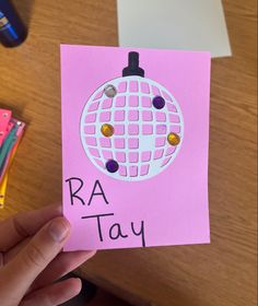 a hand holding up a pink card that says raa - tayy on it