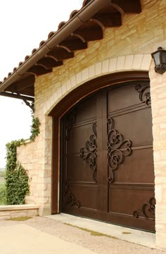 two brown garage doors in front of a brick building