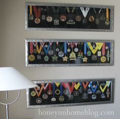 two framed medals hang on the wall above a lamp and table lamps in a living room