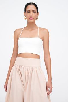 Our Claire Bralette is your new closet essential. She’s fashioned from structured, mid-stretch European ponte with soft mesh lining for ultra-breathable support, and her dynamic straps create a unique v-shape at the back. Wear this bandeau top on her own in balmy temps to enjoy sun-kissed shoulders, or style her beneath an open button-up for a crisp evening look. | Astrid, in off white and in black, is 5'9" (175 cm) tall, wearing size XS. Total length from center back is approximately 6“ (16 cm) White Chestnut, New Closet, Strappy Bralette, Closet Essentials, The A Team, Bandeau Top, Sun Kissed, V Shape, Chestnut