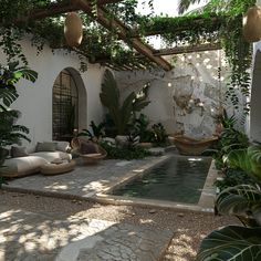 an outdoor living area with plants and potted plants on either side of the pool