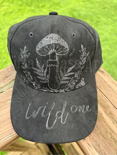 a black hat with the words wild one written on it sitting on top of a wooden bench