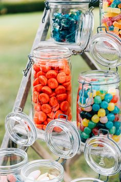 many jars filled with candy sitting on top of a table