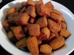 a white bowl filled with fried food on top of a table