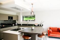 a modern kitchen with an island in the middle and two stools next to it