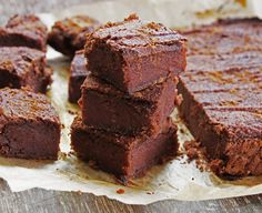 chocolate brownies stacked on top of each other with one cut in half and the other partially eaten