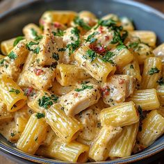 pasta with chicken and parsley in a bowl on a wooden table, ready to be eaten