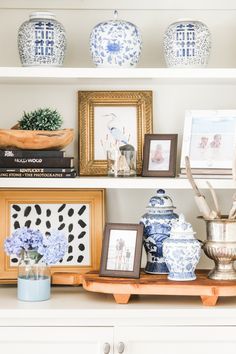 the shelves are filled with blue and white vases, pictures, and other decorative items