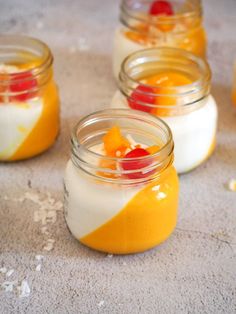 four small jars filled with food on top of a table