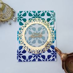 a close up of a greeting card on a table with some jewelry and a potted plant