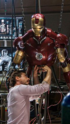 a man is working on a large iron man statue