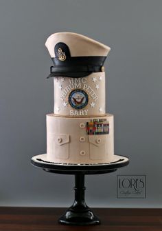 a three tiered cake with an officer's hat on top