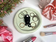 a white plate topped with lots of different types of keys and rings on top of pink satin